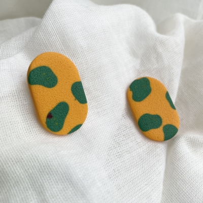 bright orange with green cow print oval earrings