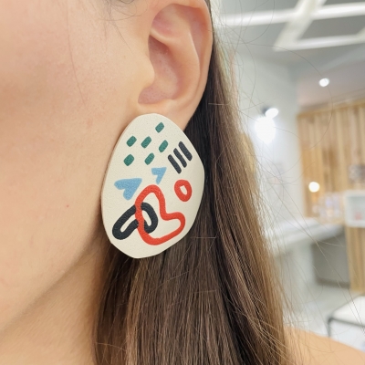 abstract handmade polymer clay earrings with colorfull art line and beige background