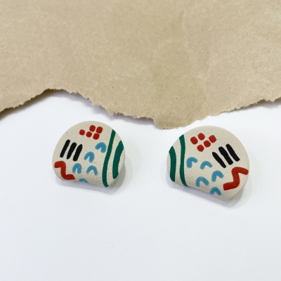 handmade curved circle polymer clay earrings with colorfull abstract lines and beige background